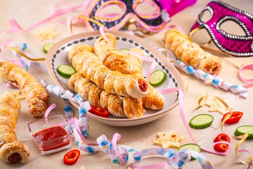 prato com enroladinho de salsicha e enfeites de Carnaval na mesa - Assaí Atacadista - snacks de Carnaval - Imagem: Shutterstock