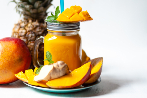 prato com um copo contendo suco de laranja com manga e gengibre - smoothies - Assaí Atacadista - Imagem: Shutterstock