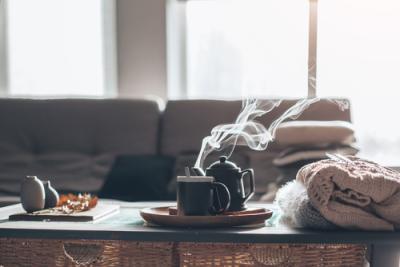 sala com sofá e uma mesa de centro com um bule e uma xícara saindo vapor - inverno - Assaí Atacadista