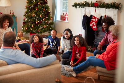 familia grande de pessoas negras felizes com trajes natalinos em uma casa com decoração de natal - Assaí Atacadista - atividades de natal