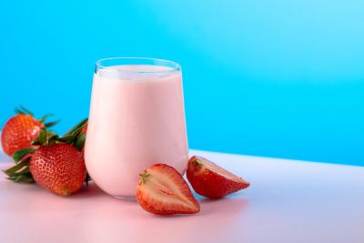fundo azul com um copo de vidro com iogurte de morango-Assaí Atacadista-LACTALIS-linha Nestle Zero