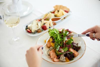 mãos brancas femininas segurando talheres com um prato de salada chique - Assaí Atacadista - Saladas chiques