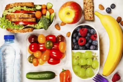 mesa com garrafa de água, frutas, barra de cereal e sanduíches naturais - lanches práticos - Assaí Atacadista