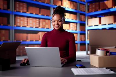 mulher negra usando notebook no estoque de uma loja-Assaí Atacadista-Lojas online