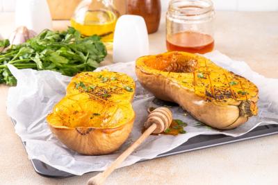 prato com uma abóbora assada cortada ao meio e ingredientes em volta - receitas veg - Assaí Atacadista