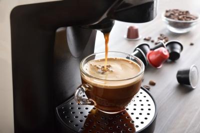 xícara com café em uma máquinha e cápsulas de café do lado-Assaí Atacadista-JDE