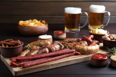 tábua com carnes em uma mesa com copos de cerveja e outros petiscos em potes-churrasco perfeito-Assaí Atacadista