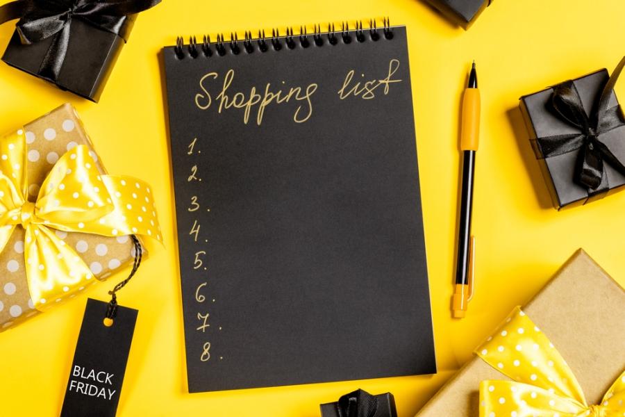 caderno preto em um frundo amarelo com caixas de presente em volta - lista de compras - Assaí Atacadista