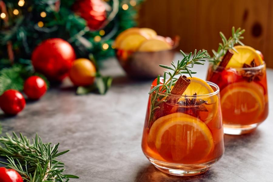 copos com drink com laranja e alecrim em uma mesa com decorações natalinas-drinks natalinos-Assaí Atacadista