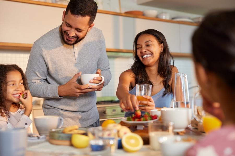 criança homem e mulher felizes fazendo uma refeição na mesa - rotina saudável - Assaí Atacadista