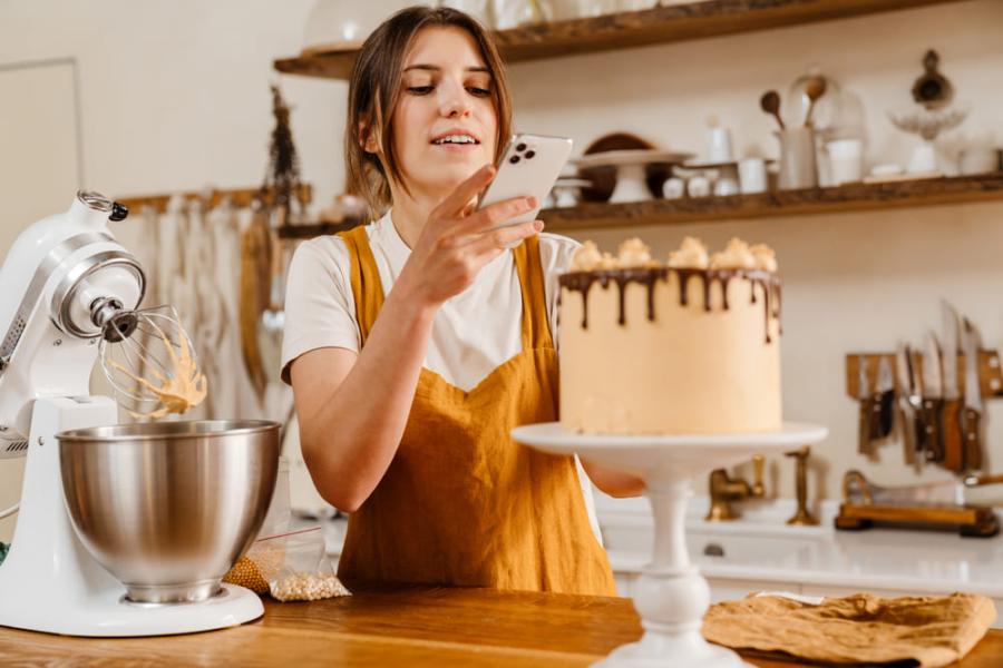 empreendedora tirando foto de um bolo - empreendedorismo - assaí atacadista