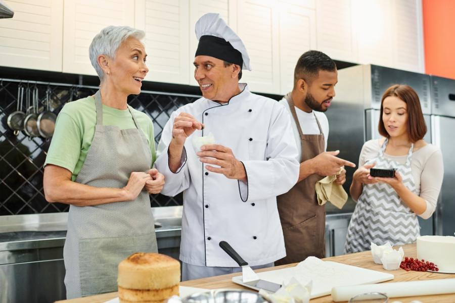 dois homens e duas mulheres em uma cozinha conversando-tipos de comerciante-Assaí Atacadista