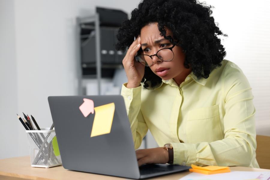 empreendedora negra olhando preocupada para um notebook - Assaí Atacadista - Black Friday para negócios