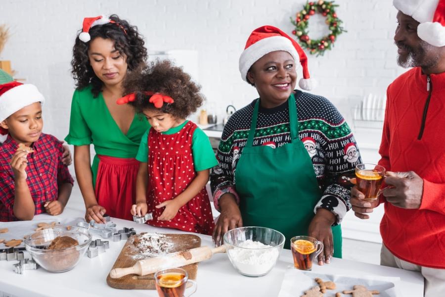 família de pessoas negras com roupas natalinas cozinhando juntos - ceia de natal - assaí atacadista
