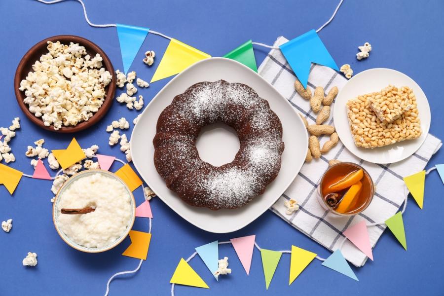 fundo azul com pratos de lanches e bandeirinhas - festa junina saudavel - Assaí Atacadista