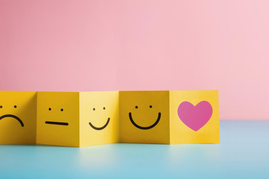 fundo rosa e azul com papel amarelo com emojis de rosto triste sério e feliz - Assaí Atacadista - feedback de clientes