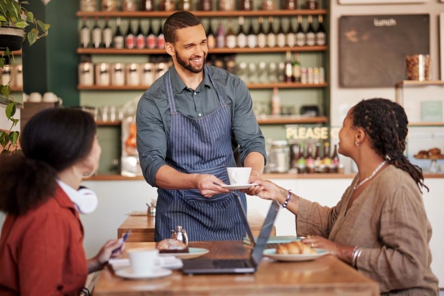 homem atendendo clientes em um café - semana do cliente assaí atacadista