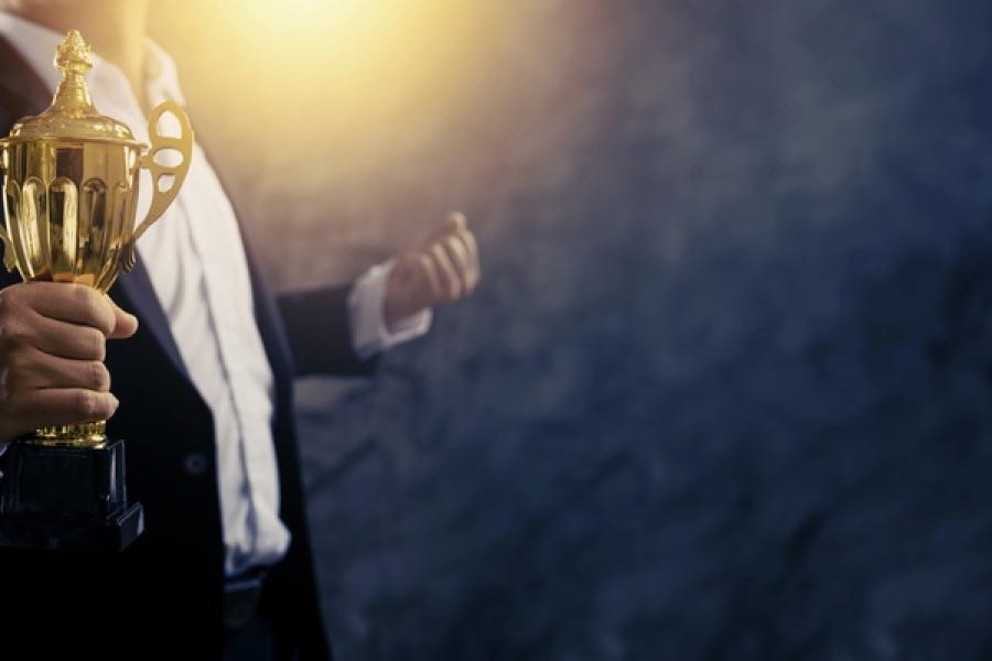 homem de social segurando troféu - Prêmio Consumidor Moderno 2024 - Assaí Atacadista