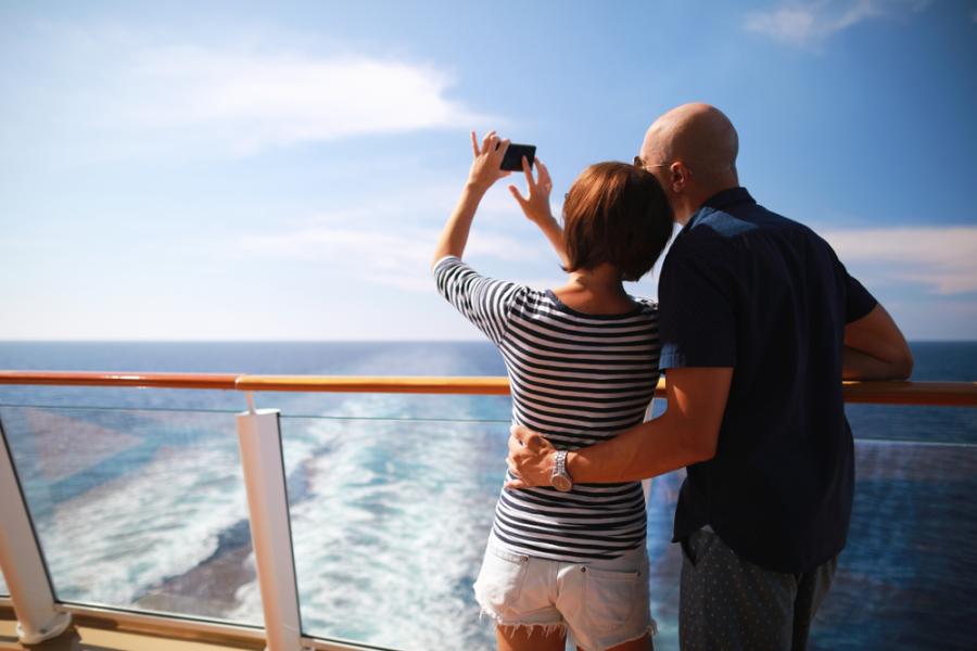 homem e mulher brancos tirando foto em um navio olhando para o mar - viagem de navio - Assaí Atacadista