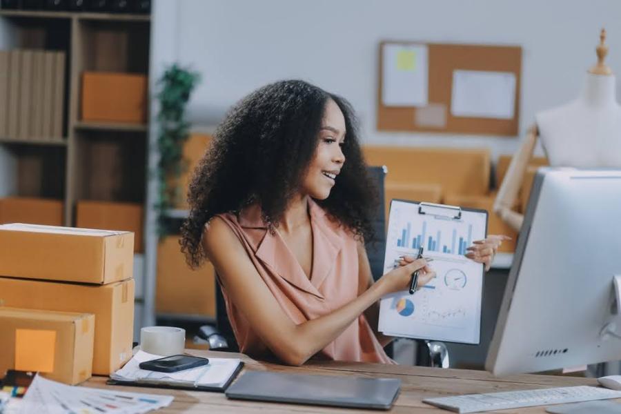 jovem negra em um escritório segurando uma prancheta com gráficos e informações - Semana do Consumidor - Assaí Atacadista - Imagem: Shutterstock