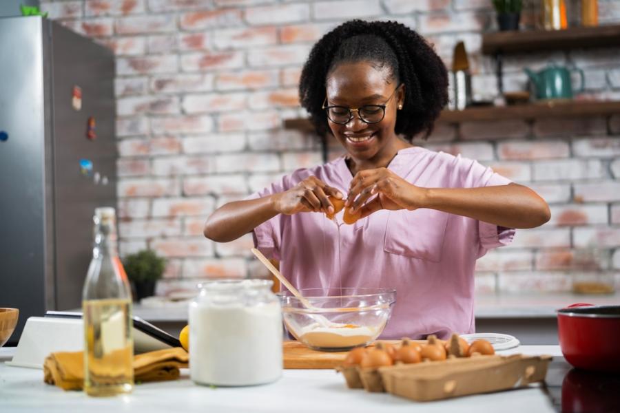 jovem negra feliz cozinhando - comércios transformadores - Assaí Atacadista