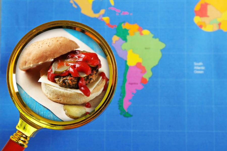 lupa com hamburguer com um mapa mundial no fundo - hamburgueres exóticos - Assaí Atacadista