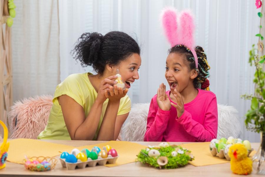 mãe e filha com orelha de coelha felizes brincando com ovos de páscoa coloridos - presentes de páscoa - assaí atacadista