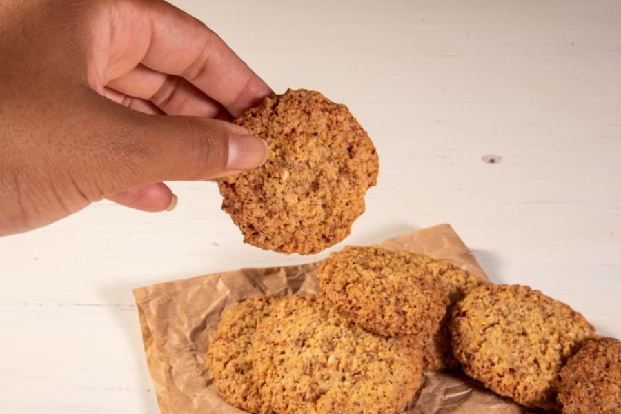 mão de uma pessoa negra segurando biscoitos - dia do biscoito - Assaí Atacadista