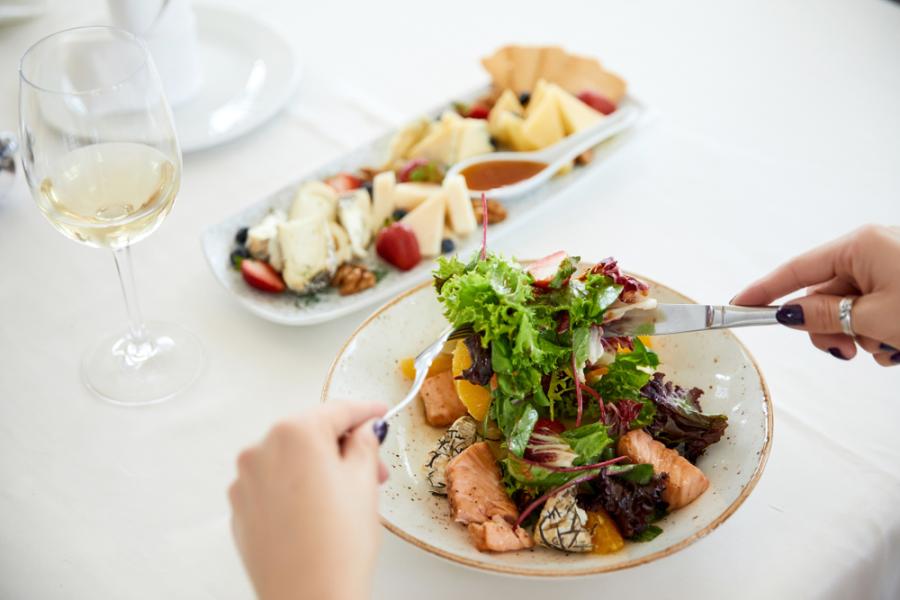 mãos brancas femininas segurando talheres com um prato de salada chique - Assaí Atacadista - Saladas chiques