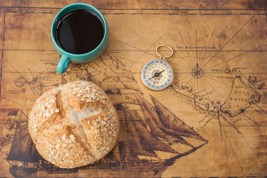 mapa antigo com pão, xícara de café e um compasso em cima - Assaí Atacadista - dia do pão