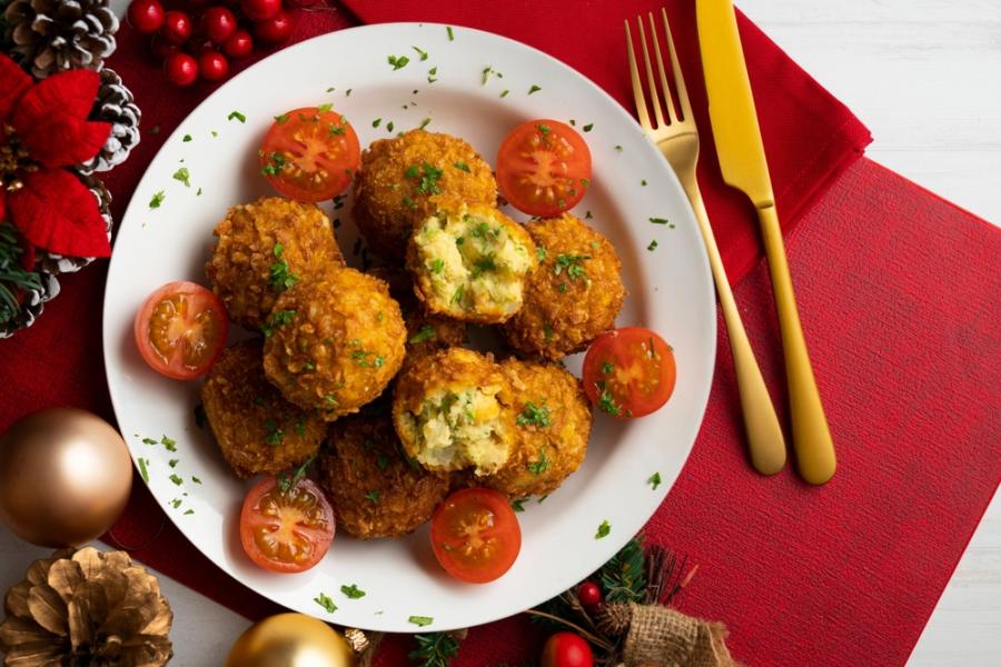 mesa com decoração de natal e um prato branco com bolinhos de grão de bico - Assaí Atacadista - natal vegetariano