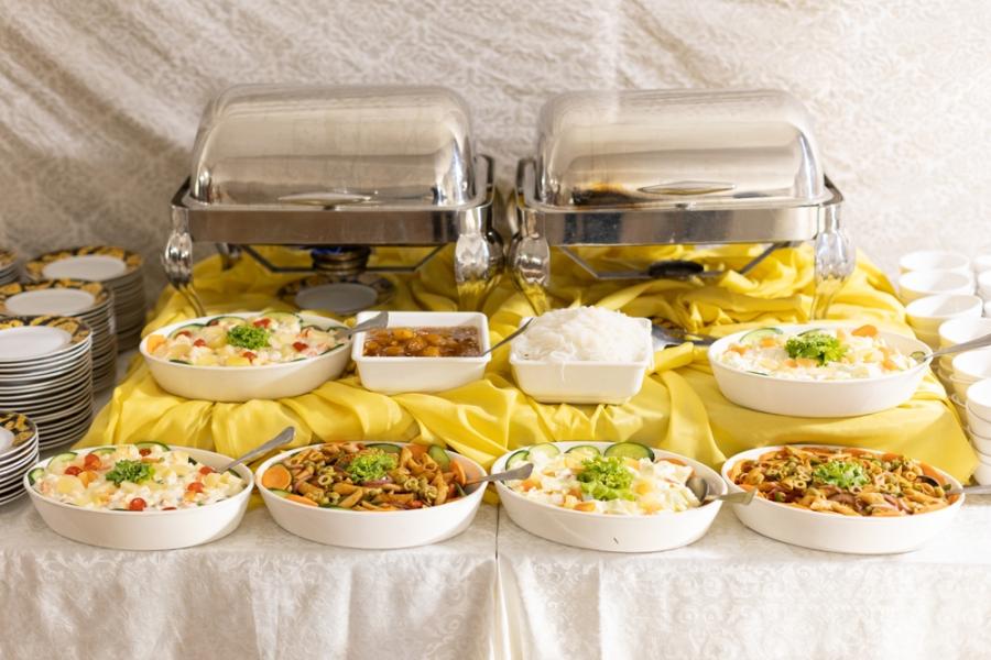 mesa de buffet com travessar cheia de comida - buffet de alimentos - Assaí Atacadista