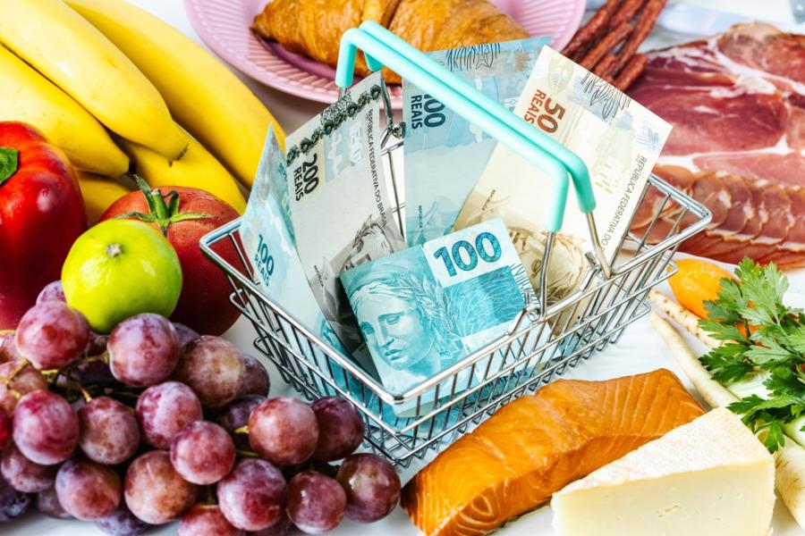minicarrinho de compras com notas de dinheiro dentro e alimentos em volta - Prêmio Academia Assaí 2024 - Assaí Atacadista