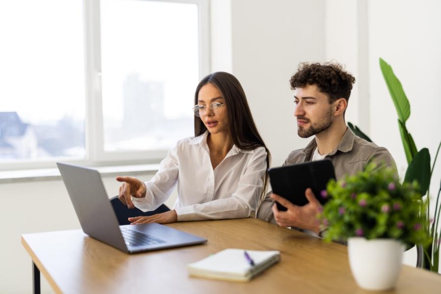 mulher e homem brancos jovens concentrados olhando para um notebook - período de experiência - Assaí Atacadista