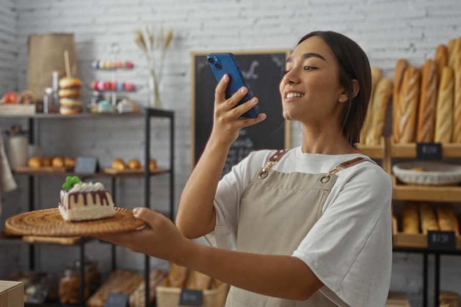 mulher jovem tirando foto de uma sobremesa em um prato-divulgação criativa-Assaí Atacadista