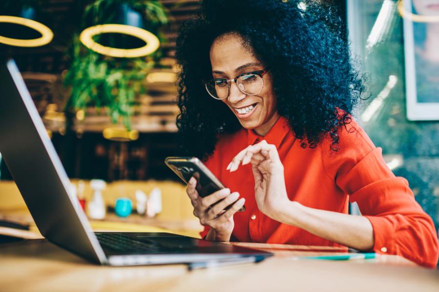 mulher negra usando celular - páginas do site Assaí Atacadista