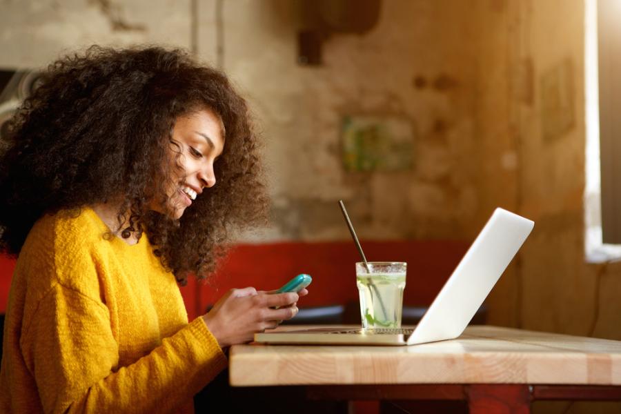 mulher negra usando celular com aplicativo para fidelização de clientes - assai atacadista