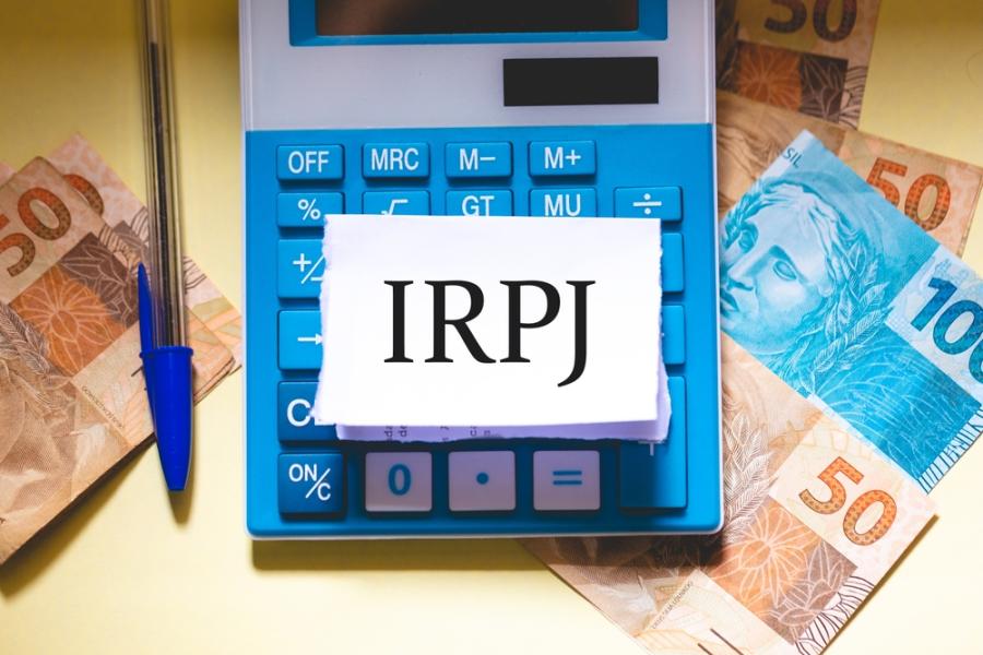 notas de dinheiro com uma calculadora e um papel com uma sigla - incentivos fiscais - Assaí Atacadista