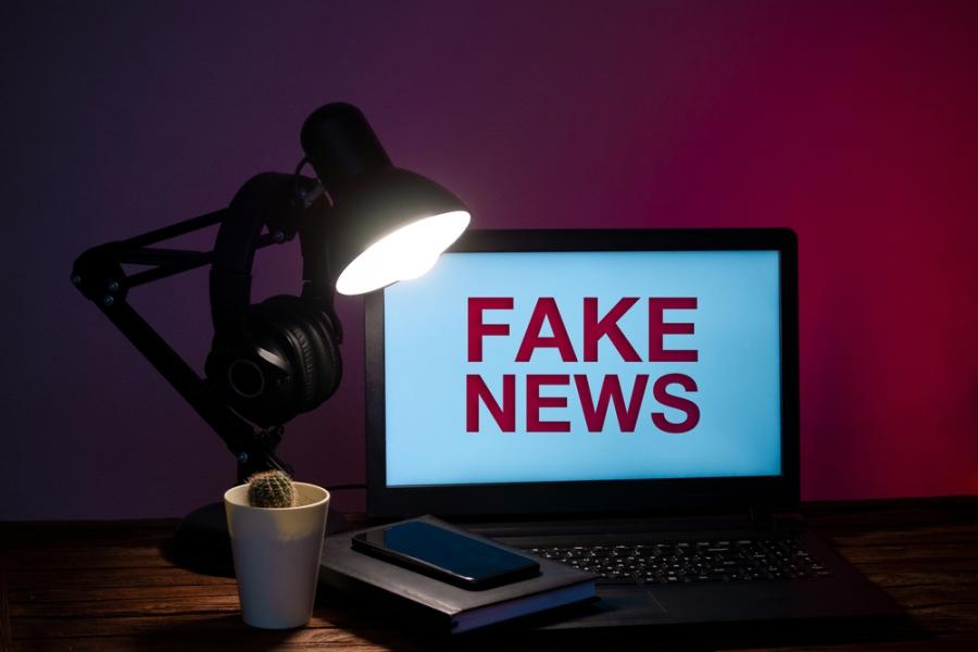 notebook em um escritório escuro com fake news na tela - Assaí Atacadista - Combate a desinformação