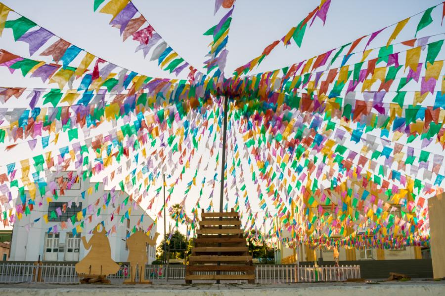 praça com fogueira e várias bandeiras em um mastro - curiosidades sobre o São João - Assaí Atacadista