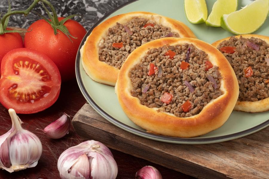 prato com esfirra de carne caseira com tomate, cebola e alho ao redor - Assaí Atacadista - petiscos fáceis - Imagem Shutterstock