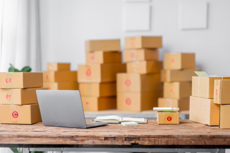 sala com várias caixas e uma mesa com notebook - queima de estoque - Assaí Atacadista