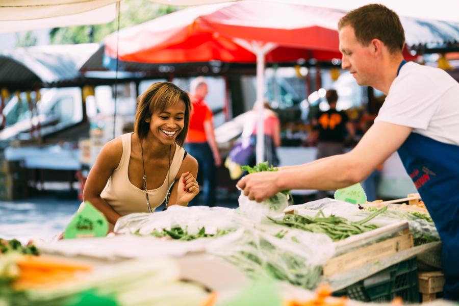 mulher negra jovem escolhendo verduras na feira - alimentos frescos - Assaí Atacadista