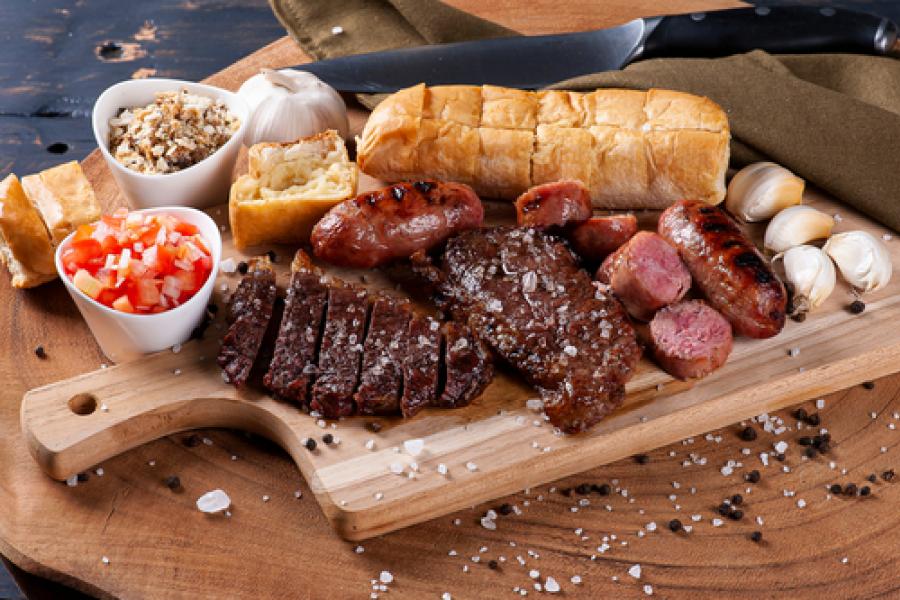 tábua com carnes assadas pão de alho e temperos diversos-churrasco de carnaval-Assaí Atacadista