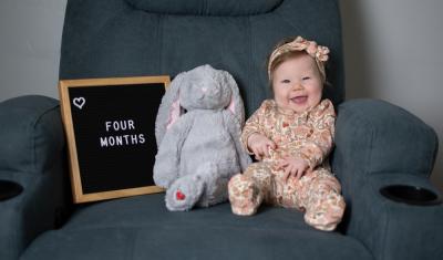 bebe branca sorrindo em uma poltrona com um ursinho e uma placa-Assaí Atacadista-Mesversário