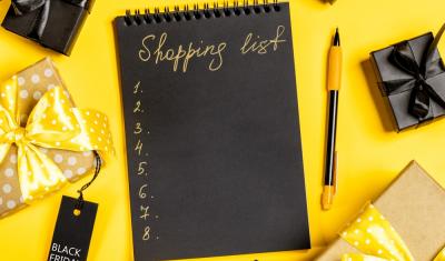 caderno preto em um frundo amarelo com caixas de presente em volta - lista de compras - Assaí Atacadista