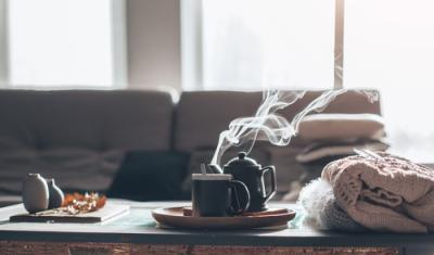 sala com sofá e uma mesa de centro com um bule e uma xícara saindo vapor - inverno - Assaí Atacadista