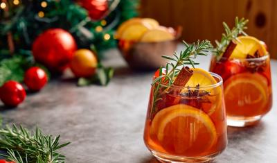 copos com drink com laranja e alecrim em uma mesa com decorações natalinas-drinks natalinos-Assaí Atacadista
