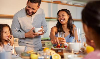 criança homem e mulher felizes fazendo uma refeição na mesa - rotina saudável - Assaí Atacadista