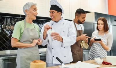 dois homens e duas mulheres em uma cozinha conversando-tipos de comerciante-Assaí Atacadista